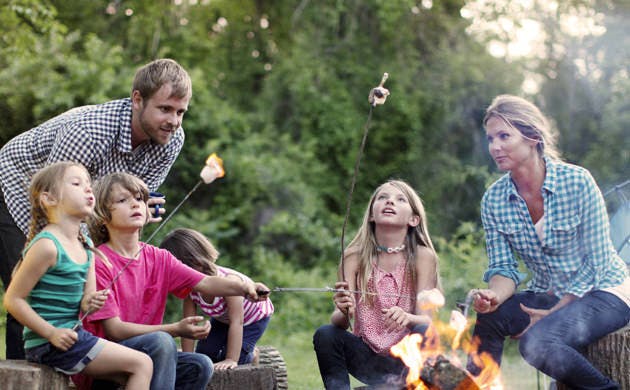 Family Roasting Marshmallows Over Campfire