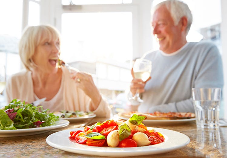 Pareja de adultos mayores tomando un almuerzo saludable.