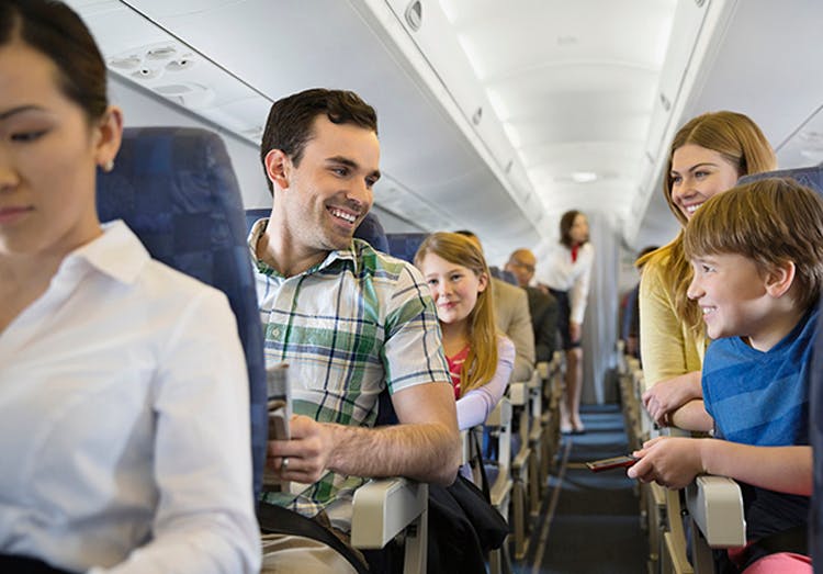 Familia sonriendo en un avión.