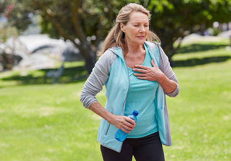 Mujer de edad haciendo ejercicio y tocandose el pecho