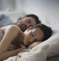 Una pareja de esposos duermen en la cama.