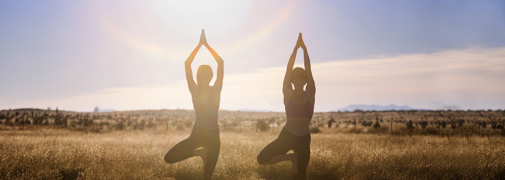 Dos mujeres haciendo Yoga al aire libre.