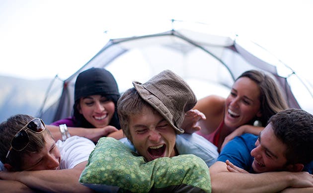 Un grupo de amigos ríen en un camping.