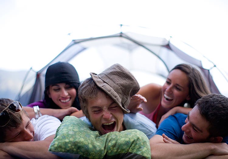 Grupo de amigos riendo en una carpa.