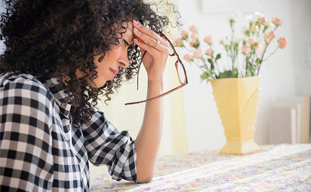 Mujer tocandose la cabeza  en señal de dolor