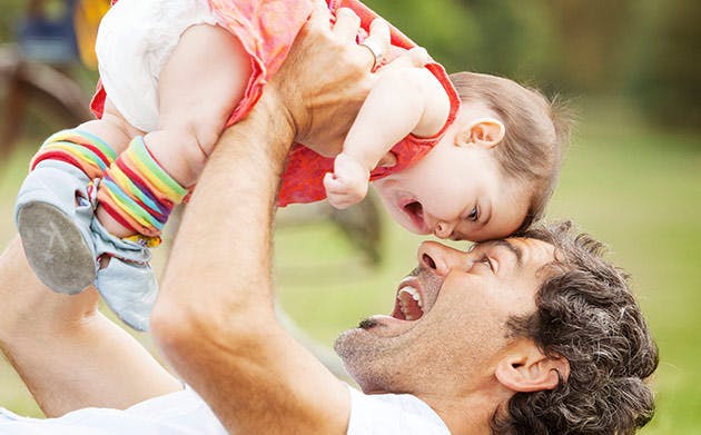 Papá carga a su hijo y juntan sus frentes.