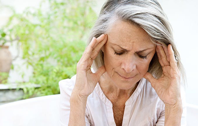 Mature Woman Touching Her Head With Her Hands