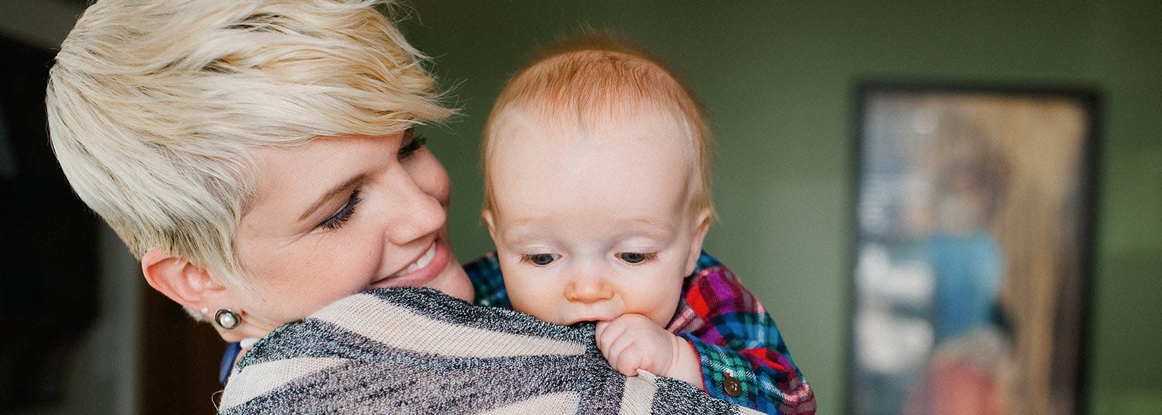 Baby Chewing Moms Sweater While She Holds Him