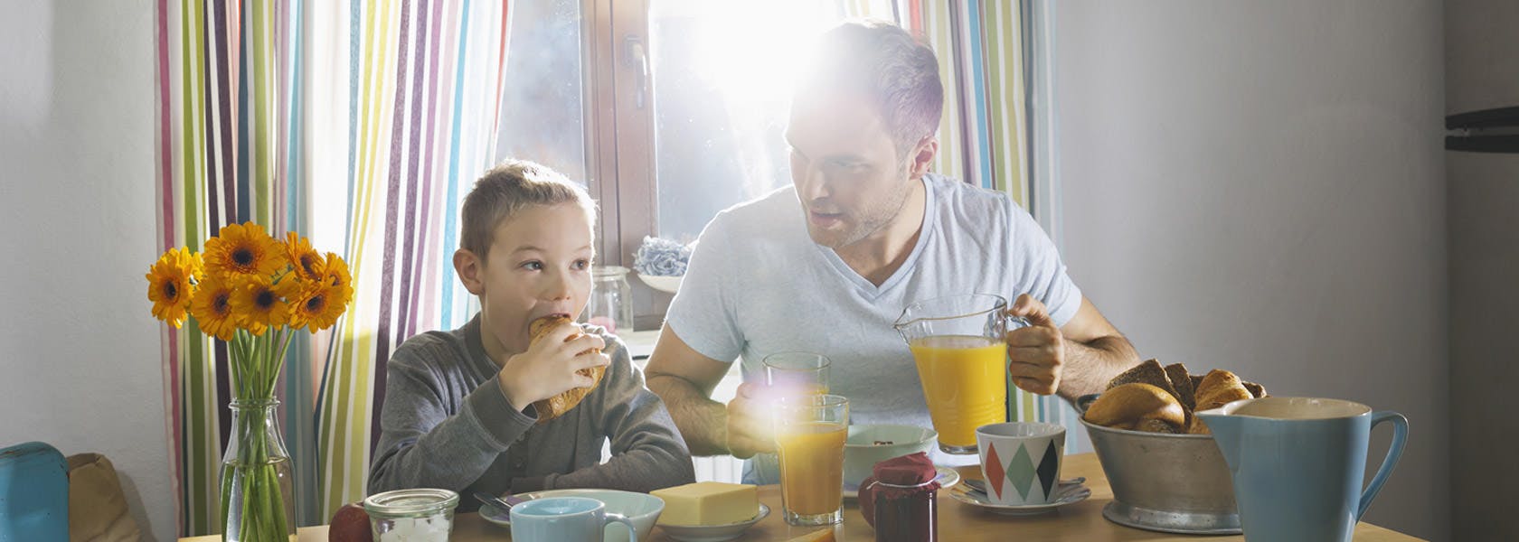Cha và con ngồi ăn sáng ở bàn ăn