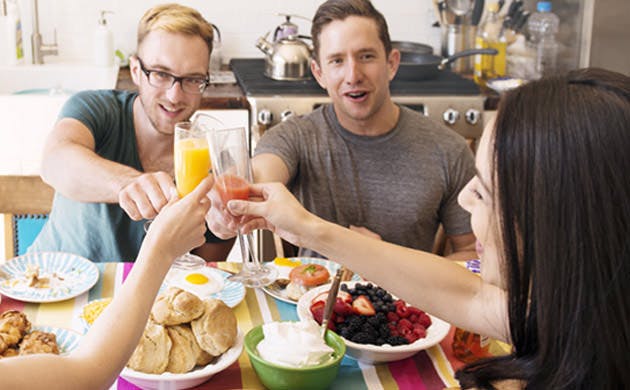 Friends Raise Their Glasses Together In A Toast At Breakfast