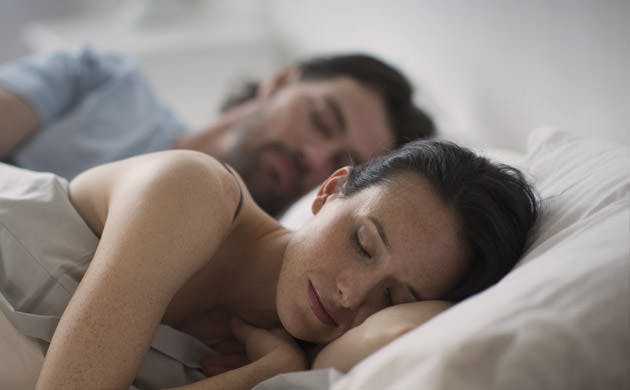 Couple Sleeping Together In Bed At Night