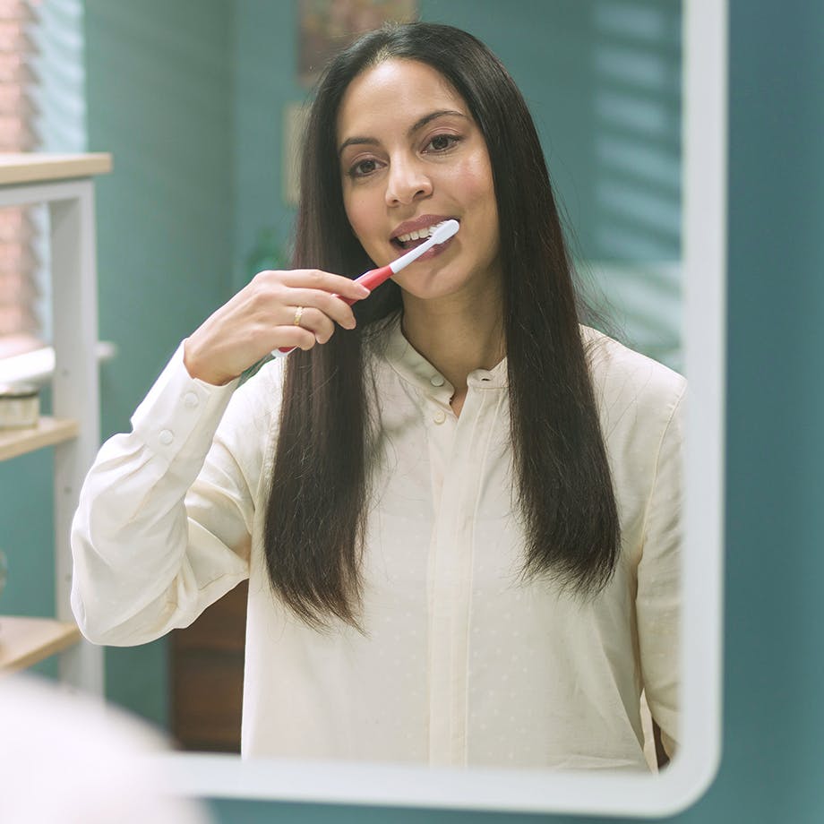 woman brushing her teeth using parodontax Complete Protection