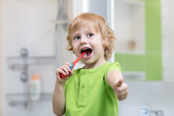 Child boy brushes his teeth in bathroom
