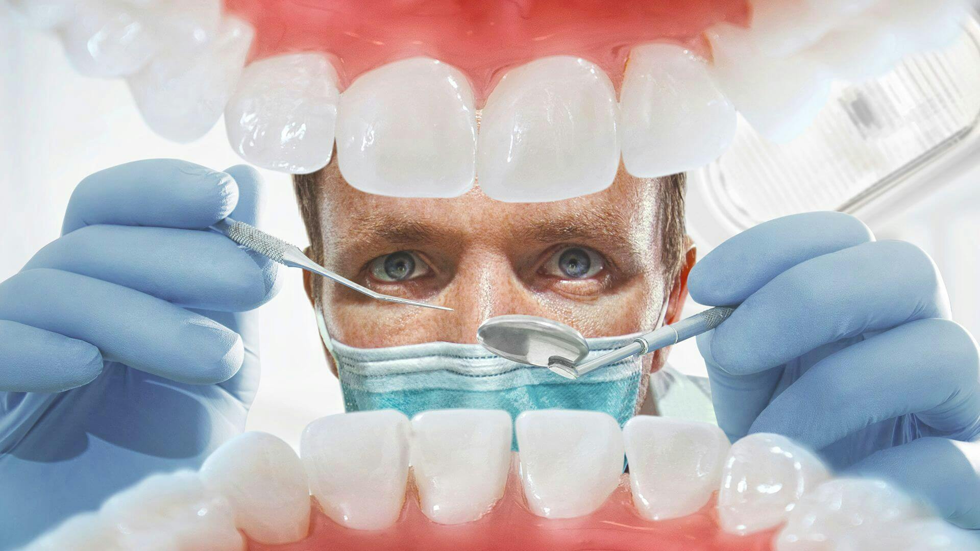 Zubní lékař, který ošetřuje zuby svému pacientovi