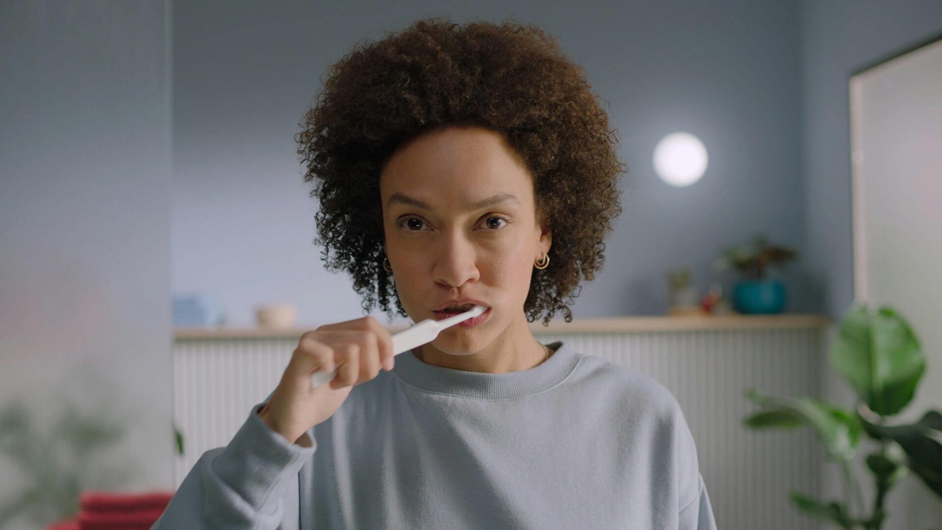 A woman brushing her teeth.