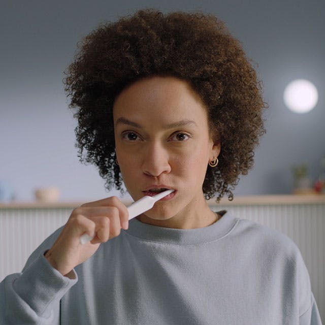 A woman brushing her teeth.