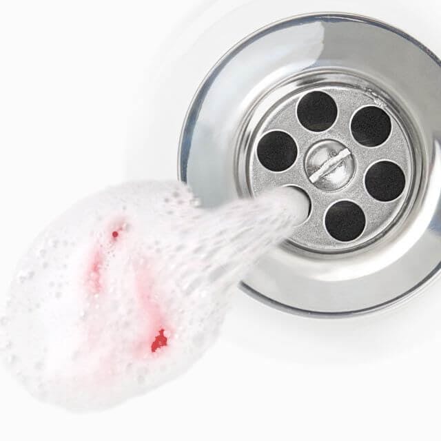 Toothpaste tainted with blood going down a drain. 