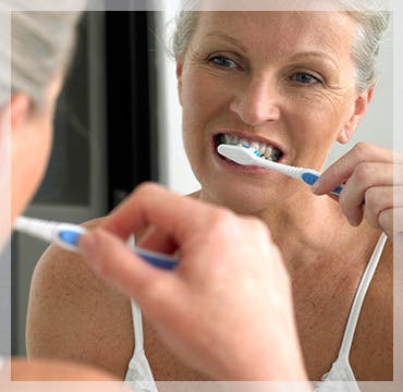 Mujer mayor cepillándose los dientes