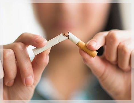 Mujer rompiendo un cigarrillo