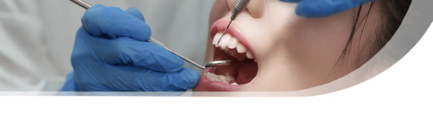 Dental hygienist performing scaling on a woman