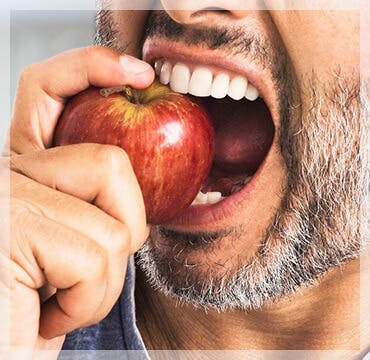 woman looking forward flossing her teeth 