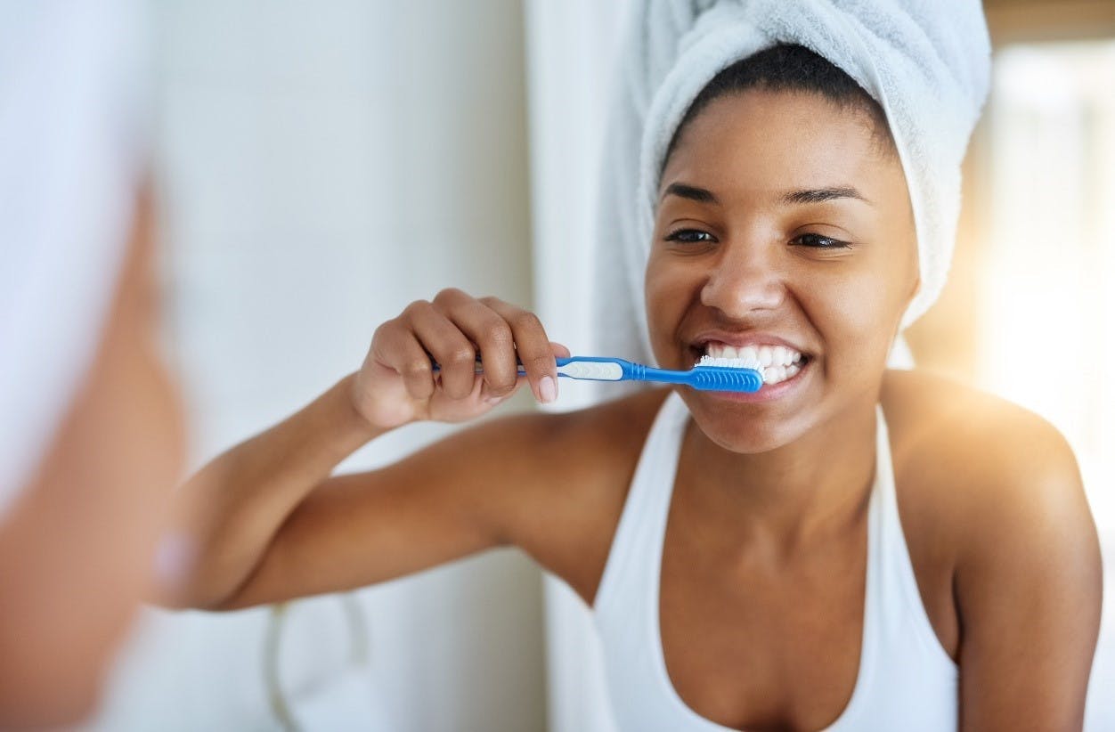 woman looking forward flossing her teeth 