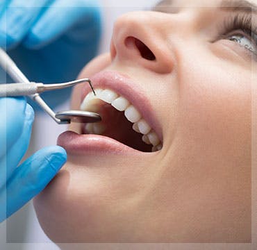 Woman getting teeth cleaned at dentist 