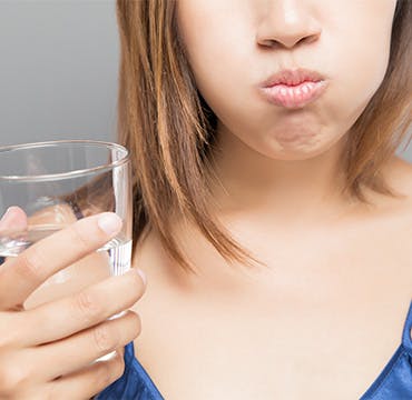 Woman rinsing her mouth with clear mouthwash