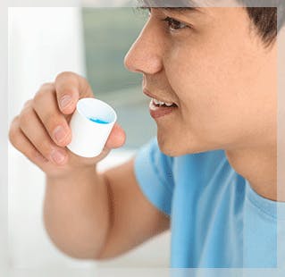 Man holding mouthwash cap