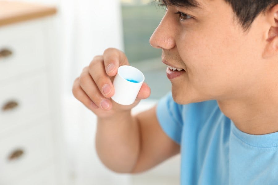 Man holding mouthwash cap