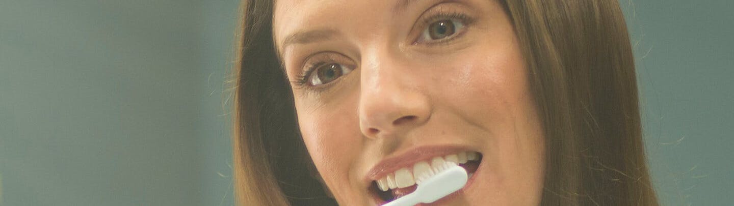 Gift kvinna borstar tänderna varsamt med parodontax tandkräm