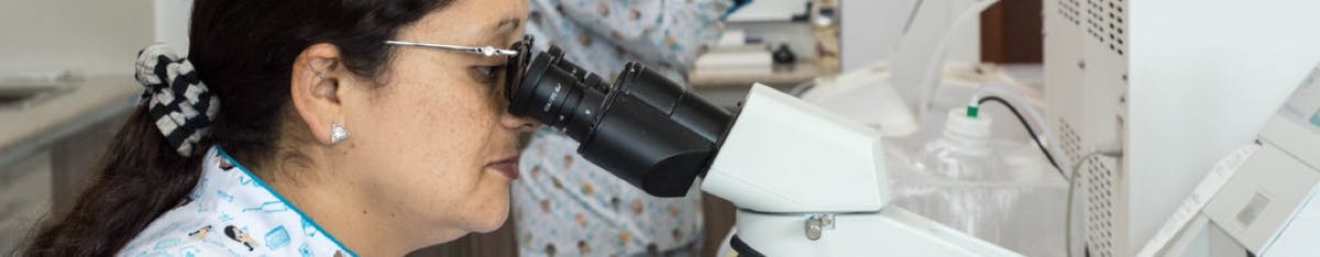 Woman loking into microscope Woman loking into microscope
