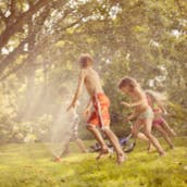 Children playing in water sprinkler