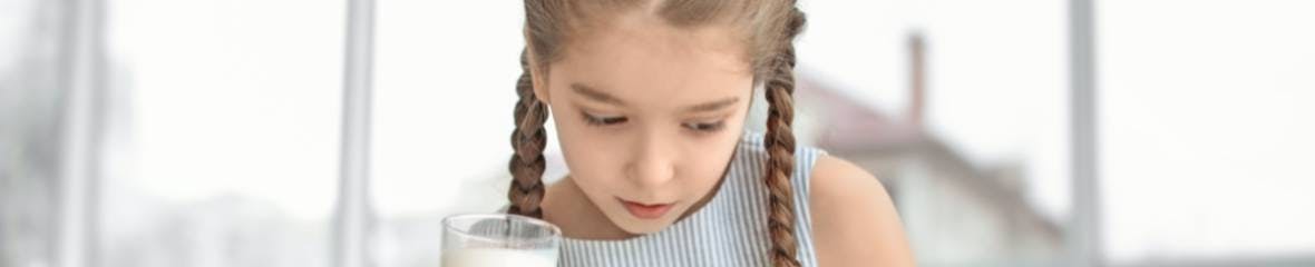 Girl holding a glass of milk, food allergies Girl holding a glass of milk, food allergies