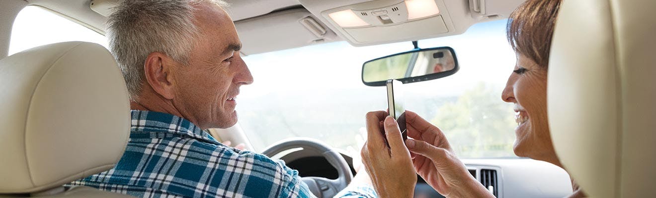 Une femme et un homme se tenant près l'un de l'autre en voiture