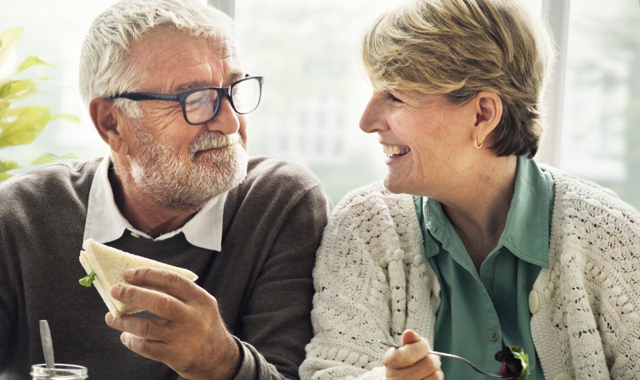 Aged couple smiling at each other and having a friendly talk