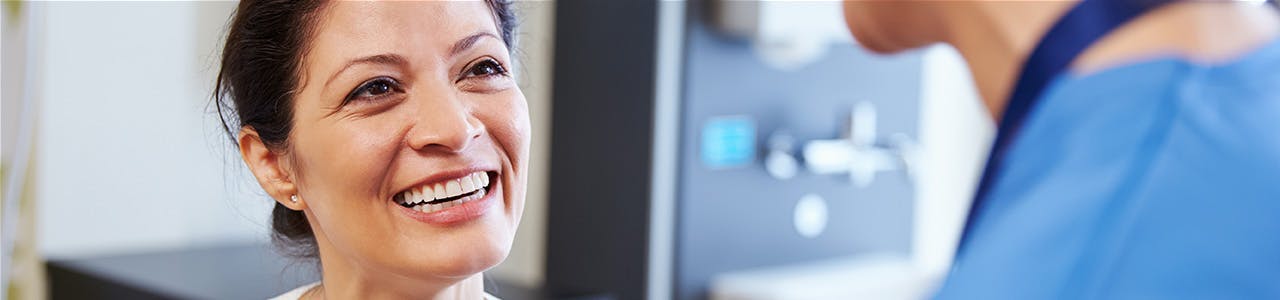 Smiling woman talks to a dental professional