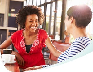Two women sitting on chairs and having a friendly talk 