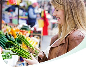 Femme au sourire éclatant qui choisit des légumes