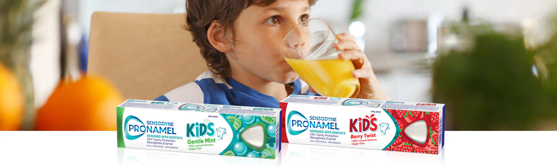 Small boy drinking acidic orange juice from a round glass