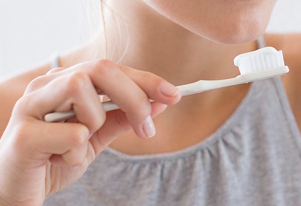 woman brushing her teeth with pronamel