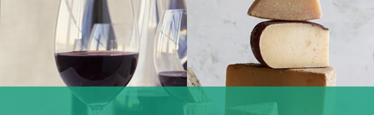 Deux verres de vin rouge avec trois morceaux de fromage empilés