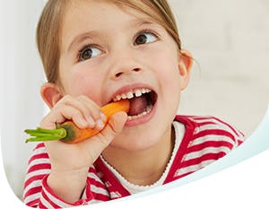 Young girl eating a carrot