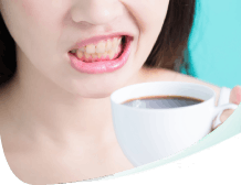 A woman who has yellow teeth from drinking coffee