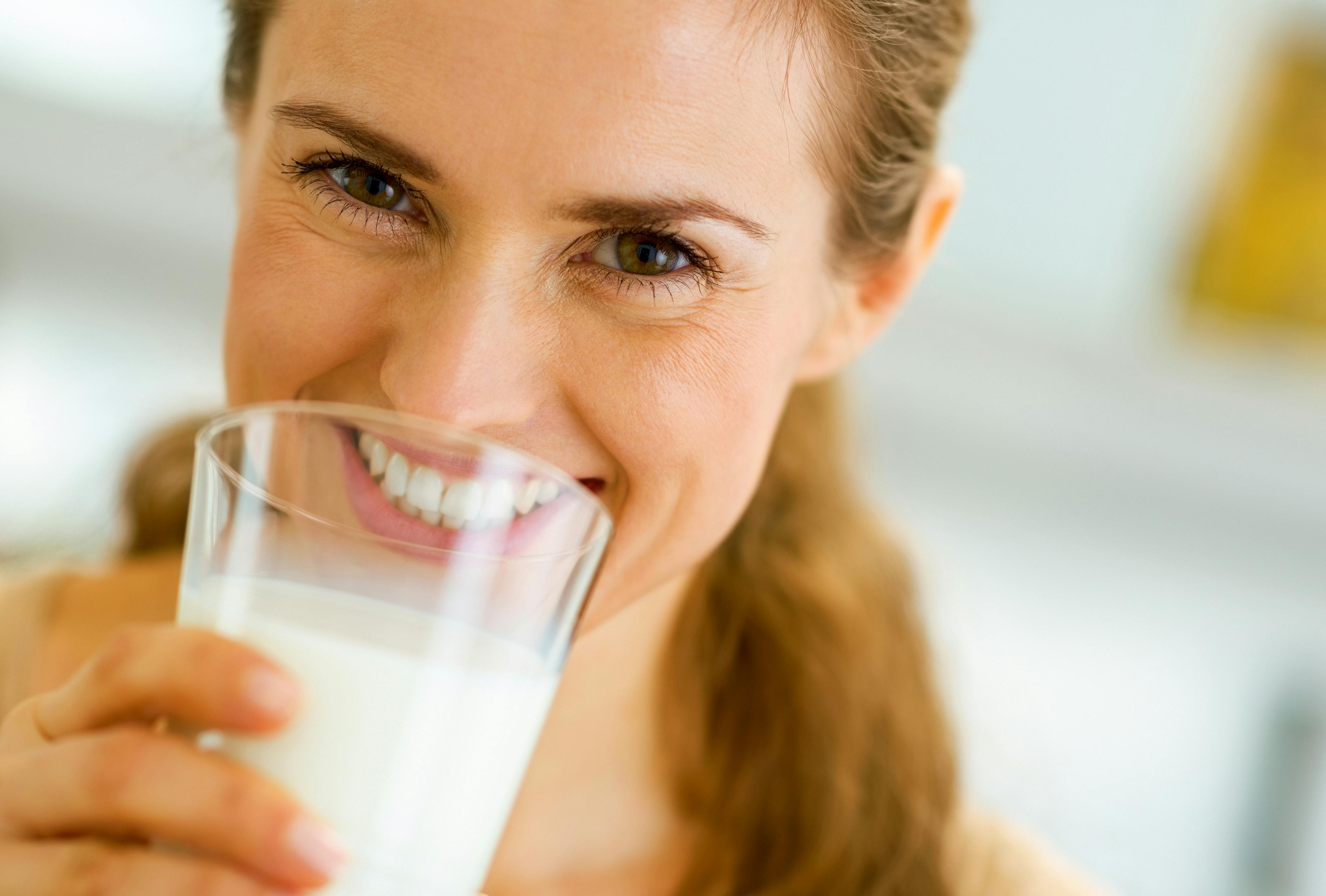 1030907580 woman drinking milk and smiling