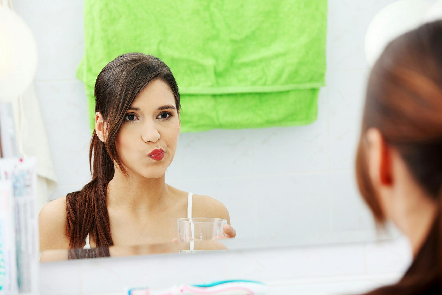 Young woman rinsing with mouthwash