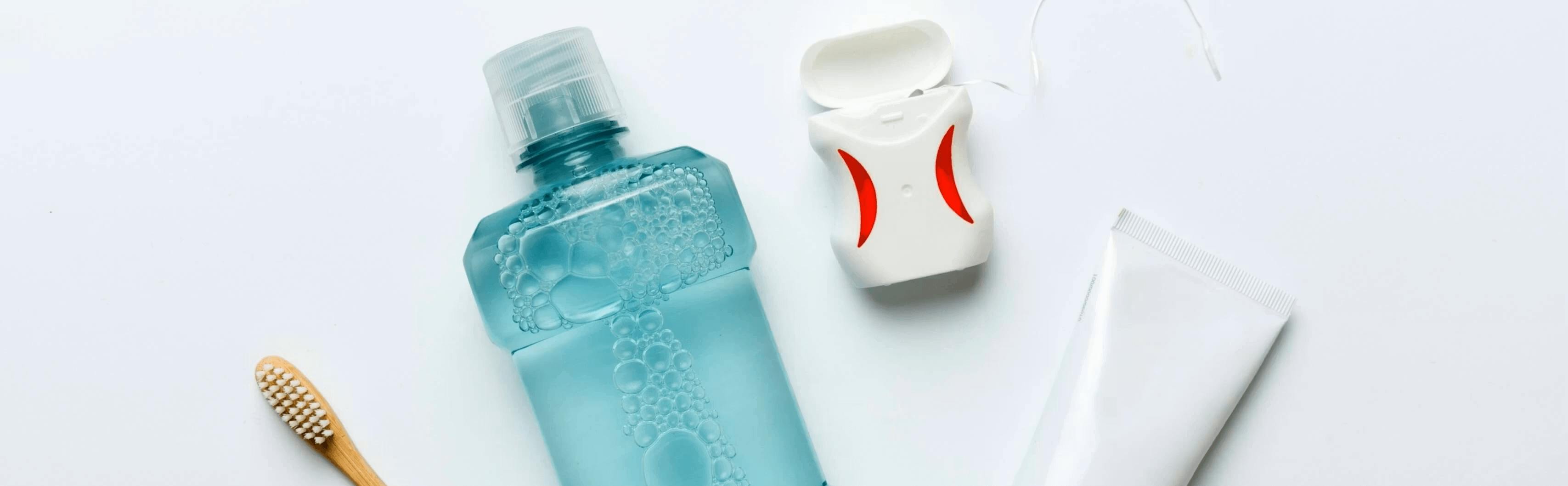 Mouthwash is shown with floss, a toothbrush and toothpaste