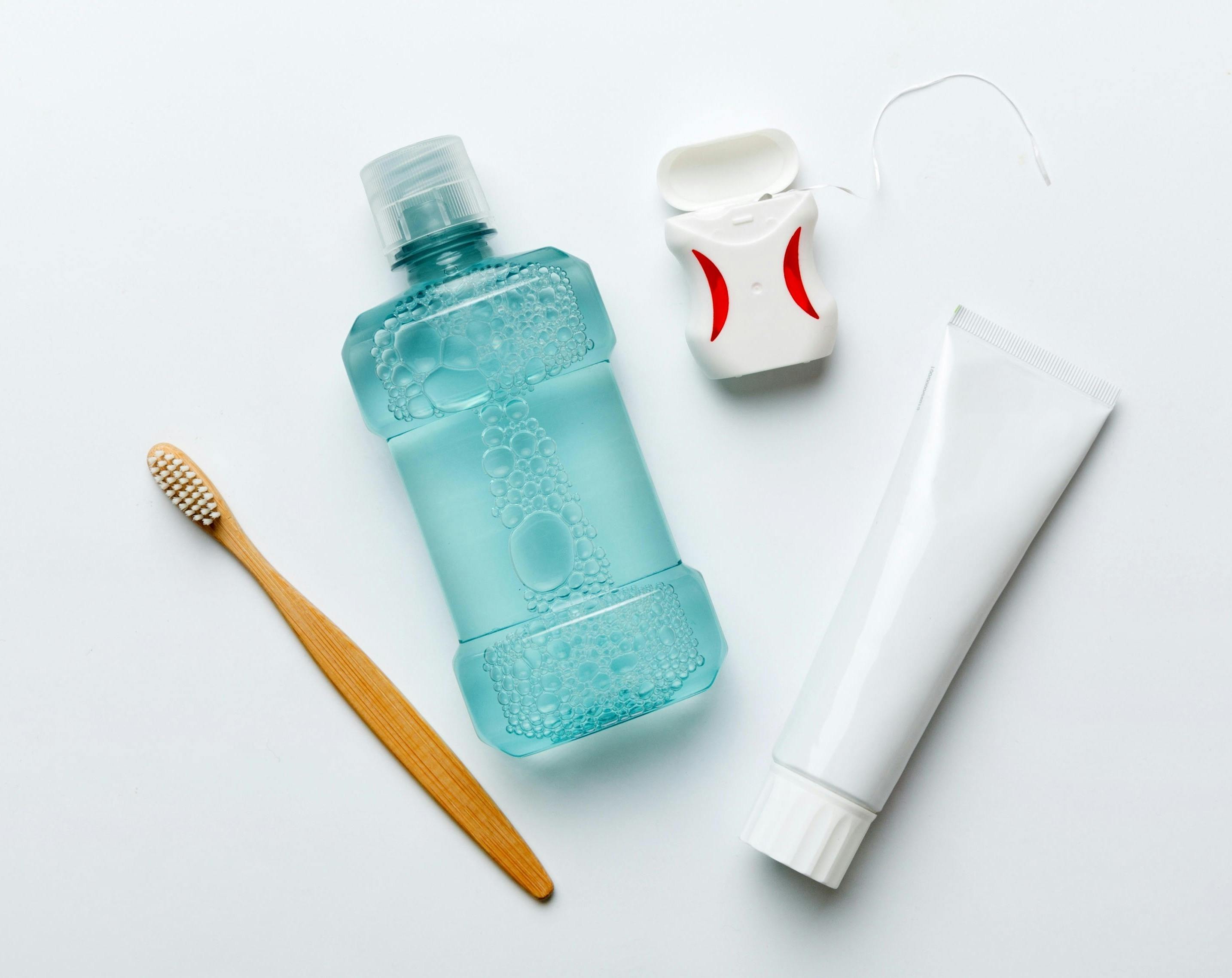 Mouthwash is shown with floss, a toothbrush and toothpaste