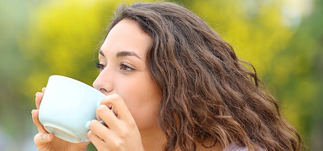 A woman drinking from a mug