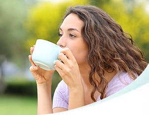 A woman drinking from a mug